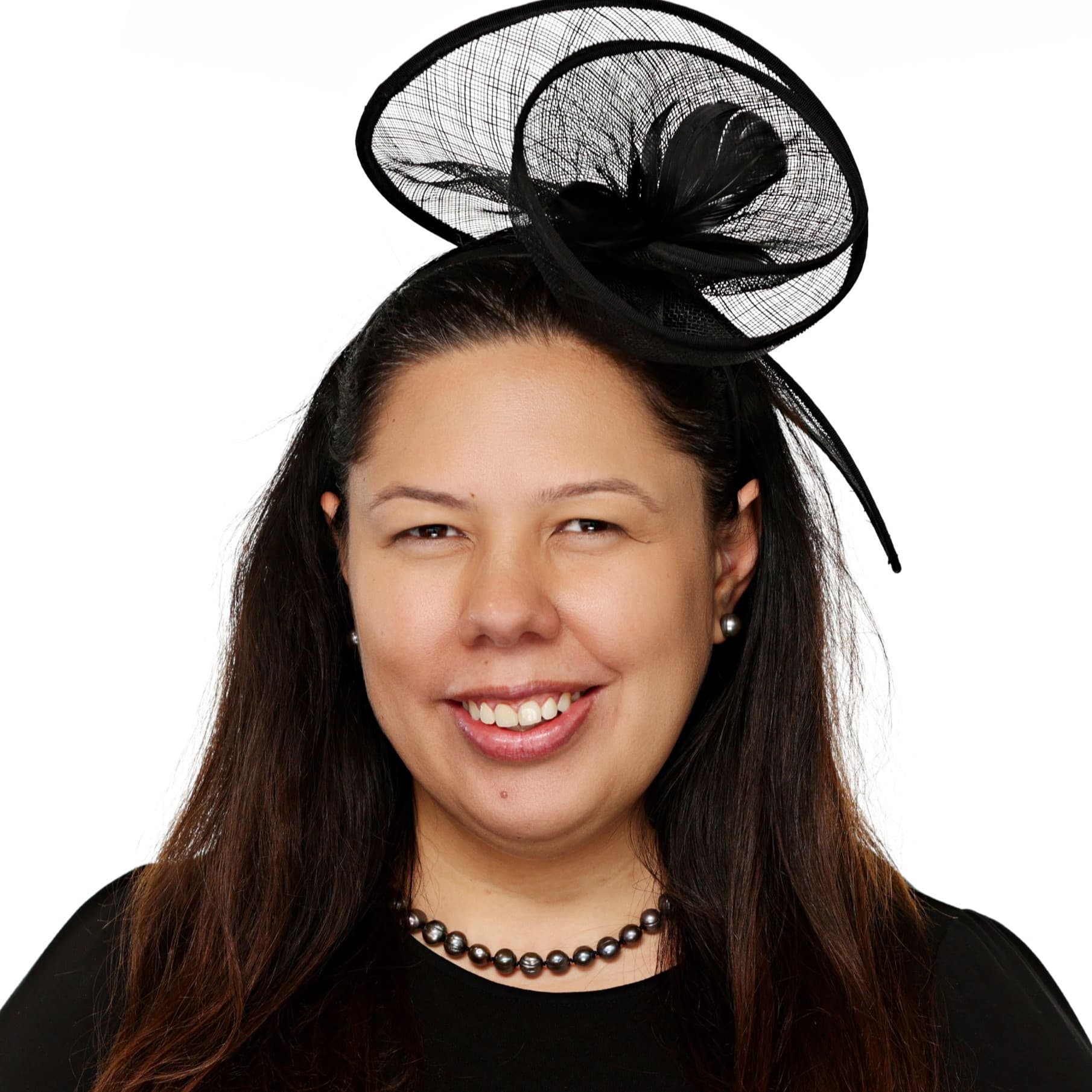 Rubina Carlson, smiling, in a black top and black fascinator.